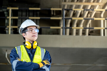 Asian male inspection engineer standing with arms crossed. Confident man construction worker with...