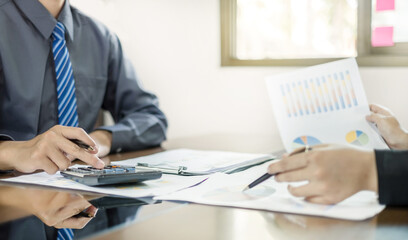 Two business leaders talk about charts, financial graphs showing results are analyzing and calculating planning strategies, business success building processes