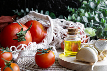 Close-up shot of healthy Mediterranean ingredients: olive oil, garlic and red tomatoes in a sustainable shopping bag.