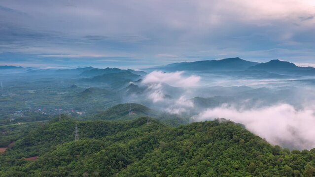 4K motion time lapse video aerial view morning scenery Mist flowing over the high mountains The movement of fog and clouds, Pang Puey, Mae Moh, Lampang, Thailand	