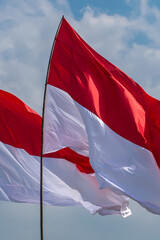 The red and white flag flutters in the sky