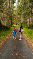 Fototapeta premium A couple of young lesbian women walk hand in hand along a rural path during a nature excursion in Galicia