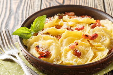 Fresh egg pasta Girasoli sunflower shaped with cheese, basil and bacon on plate on the wooden table. Horizontal