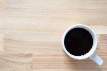 A cup of coffee on a blurred wooden background