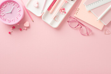 Fototapeta na wymiar Schoolgirl's stationery collection: pens, pencil case, erasers, hearts, ruler, book, copybooks, clips, pins, glasses, alarm clock, all neatly arranged on a pastel pink background. Ad space available