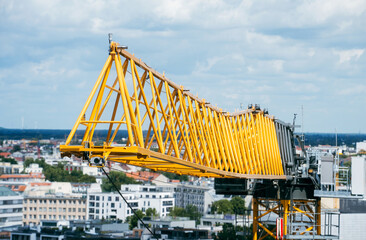 Naklejka premium high angle close view of the jib of a yellow Tower crane on a construction site of a building