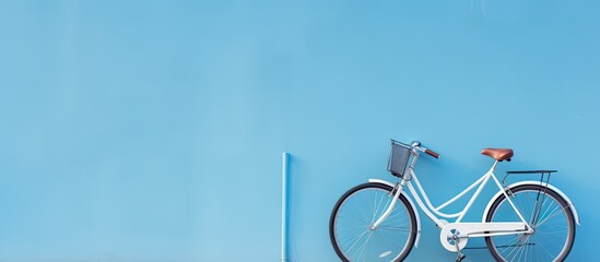 A high-quality photo of a bicycle is positioned against a blue wall, with empty space available