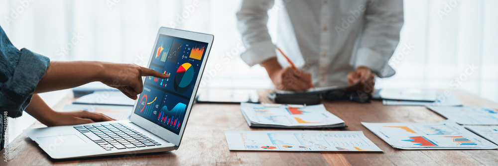 Leinwandbilder Panorama shot analyst team utilizing BI Fintech to analyze financial report with laptop. Businesspeople analyzing BI power dashboard displayed on laptop screen for business insight. Scrutinize