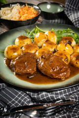 Traditional German braised pork cheeks in brown sauce.