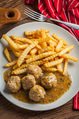 Meatballs with french fries in dill sauce.