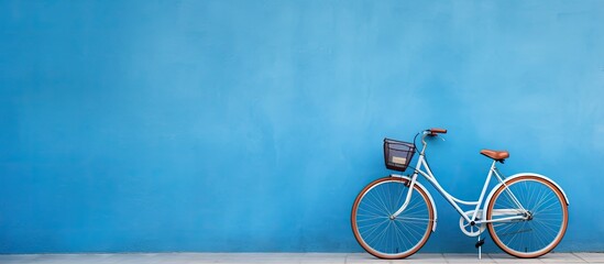 A high-quality photo of a bicycle is positioned against a blue wall, with empty space available - Powered by Adobe