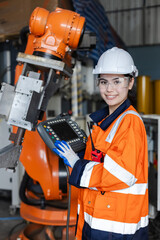 female technician engineer looking at camera holding remote control automation robotics at...