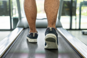 Male runner exercise indoor gym. fitness man jogging wearing sportswear. Workout and healthy Young athlete running on the treadmill.