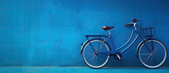 A high-quality photo of a bicycle is positioned against a blue wall, with empty space available