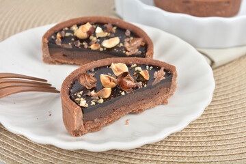 freshly handmade beautiful France rocher dark chocolate layer tart w mixed macadamia peanuts on white marble luxury background with bamboo decoration halal food dessert menu for cafe