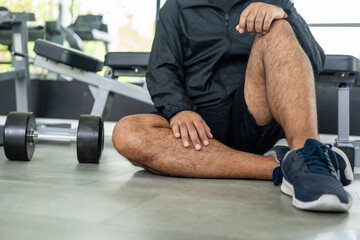 Young fitness Man sitting in sport gym. Relaxing after work out