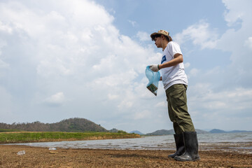 Male volunteers collecting garbage, conducting environmental cooperation, saving world reducing...