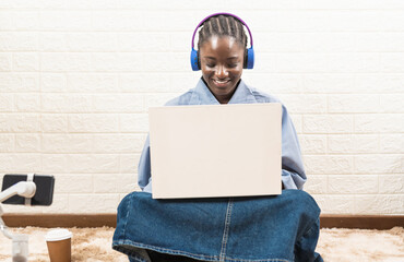 Young smiling African American student wearing headphones and having virtual education meeting class