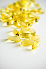 Fish oil supplement capsules on a white surface as a background. Oil filled capsules of food supplements. Fish oil, omega 3.