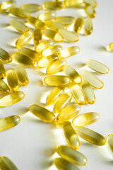Gelatin capsules of omega 3, 6, 9 fish oil, vitamin isolated on a white surface as a background.