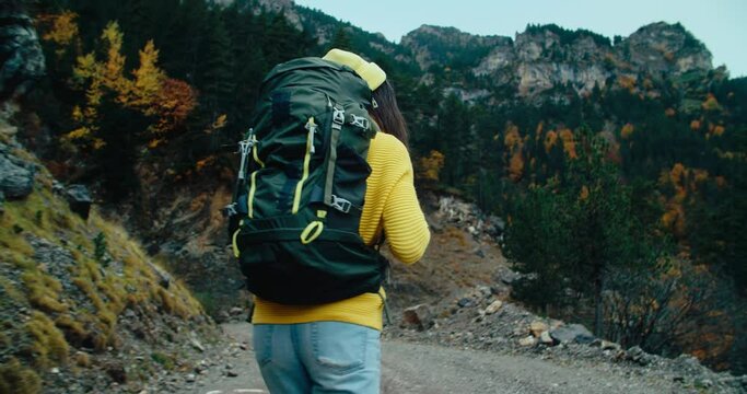 Female backpacker on mountain path adventure on autumn season