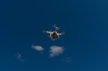Quadcopter in a blue and clear sky on its way to 
