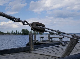 Rope made of natural materials on a wooden block on the deck of an ancient ship. Rigging on a ship...