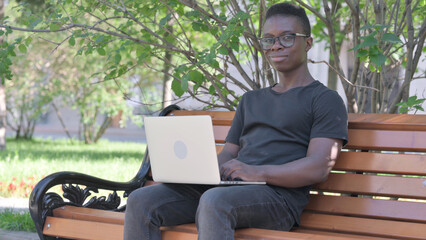 Fototapeta premium Young African Man Shaking Head in Acceptance while Using Laptop Outdoor