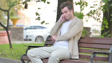 Fototapeta premium Sleeping Casual Young Man Sitting Outdoor on Bench