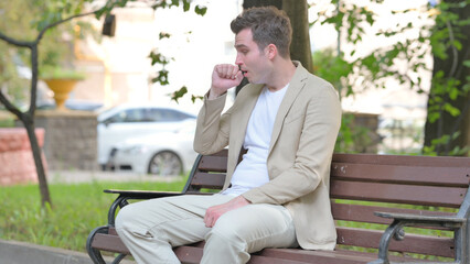 Obraz premium Coughing Casual Young Man Sitting Outdoor