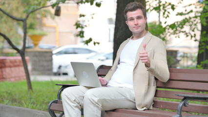 Thumbs Up by Casual Young Man on Laptop Outdoor