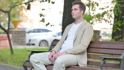Fototapeta premium Serious Casual Young Man Sitting Outdoor