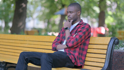 Fototapeta premium Serious Young African Man Sitting Outdoor