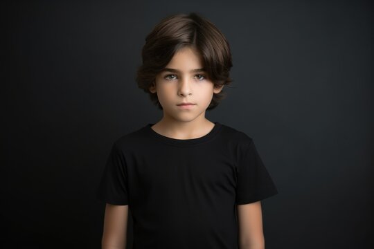 Portrait of a fictional young little boy wearing a plain black t-shirt. Isolated on a plain neutral background. Generative AI.