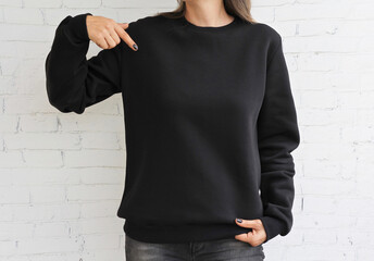 Woman wearing Black sweatshirt mockup with copy space. with natural stone wall