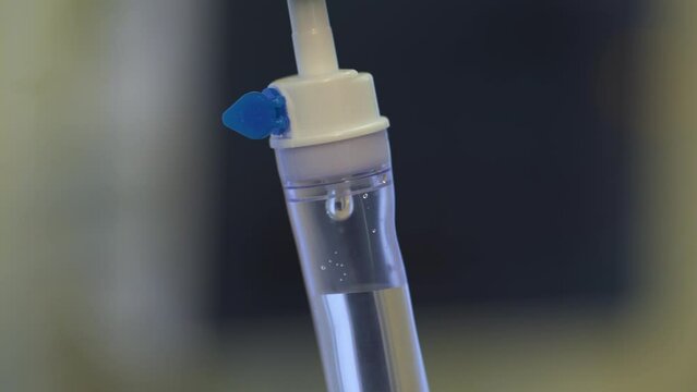 A ward in a hospital, a close-up of drops of saline in a drip, the solution is slowly falling. Treatment of the disease, medicine after surgery