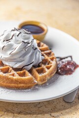 waffles topped with whipped cream and chocolate on a plate