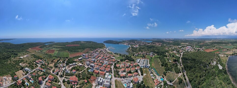 Panoramic shot of a coastal town and marina with urban buildings and a port in Volme, Croatia