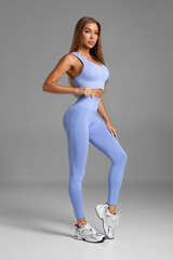 Fitness woman. Athletic girl on the gray background - 631540793