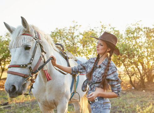 cowgirl in hat hugging her horse