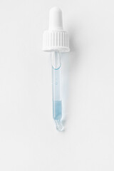 Cosmetic pipette with blue and blue gel, serum, serum on a light background.