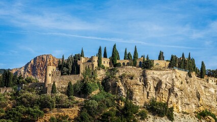 Scenic view of a castle perched atop a hill surrounded by lush greenery: Cassis, France