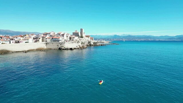 Aerial of the white buildings of Brindisi city in Italy alongside the blue sea