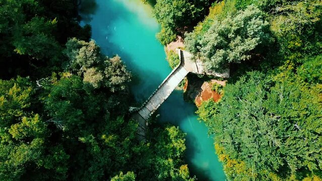 Drone footage over the stone bridge of Pont Des Tuves, on a turquoise river in Montauroux, France