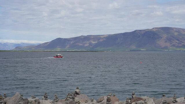 Small red boat in Faxafloi bay in Reykjavik, Iceland