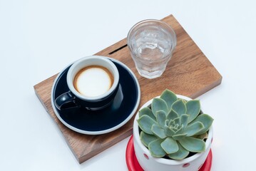 Closeup of a shot of espresso with a glass of water on a tray on the table