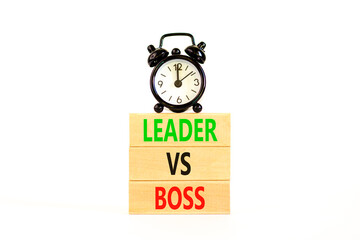 Boss vs leader symbol. Concept words Boss vs versus leader on wooden block. Beautiful white table white background. Black alarm clock. Business motivational boss vs leader concept. Copy space.