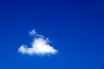 Single white cloud in blue sky. Bright blue sky with white puffy clouds