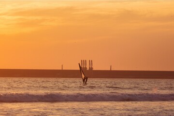 Windsurfer riding towards the middle of the dock at sunset in Portugal.