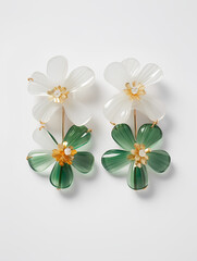 earrings in the form of flowers, two white and green flowers on each earring, flowers made of glass or acrylic on a white background, objective shooting of women's accessories
